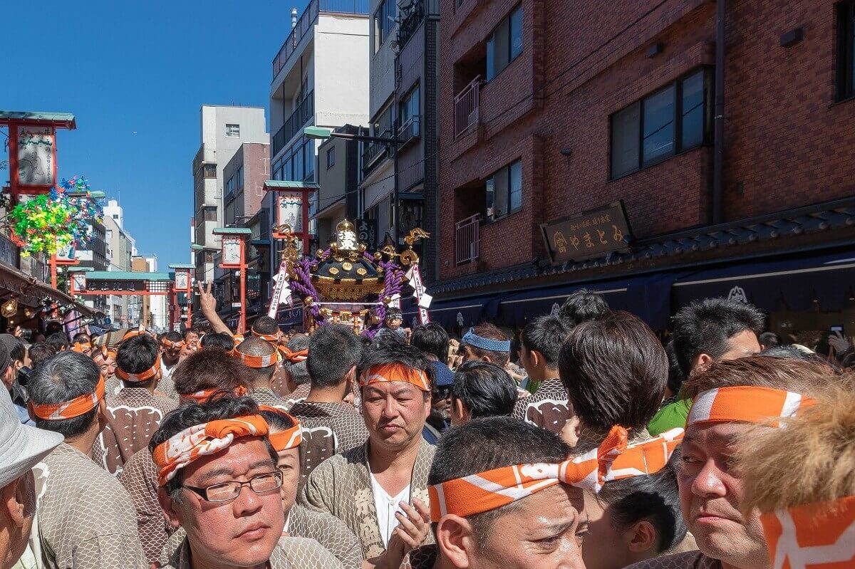 Große Menschenmenge, im Hintergrund ist ein Mikoshi zu sehen